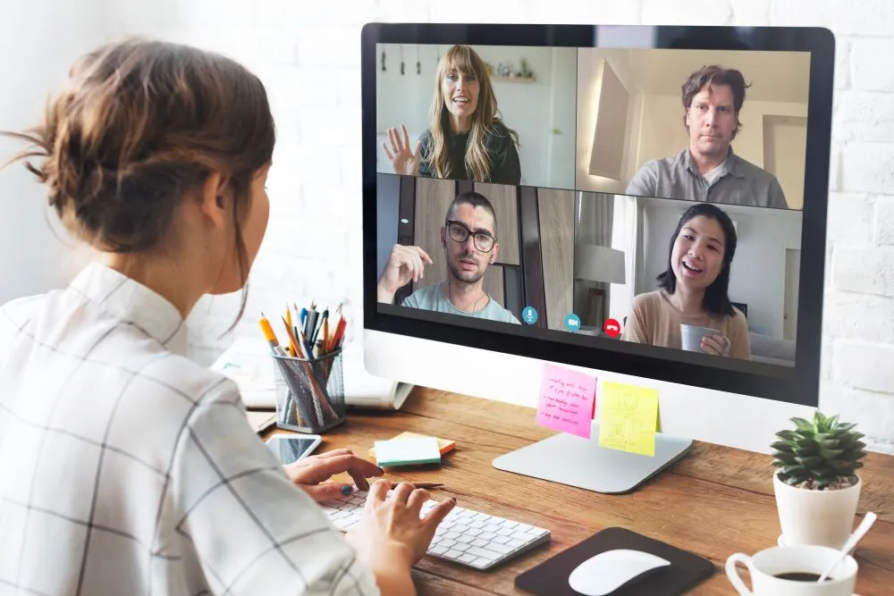 Une femme fait du management hybride en visio conférence sur un ordinateur Une femme fait du management hybride en visio conférence sur un ordinateur
